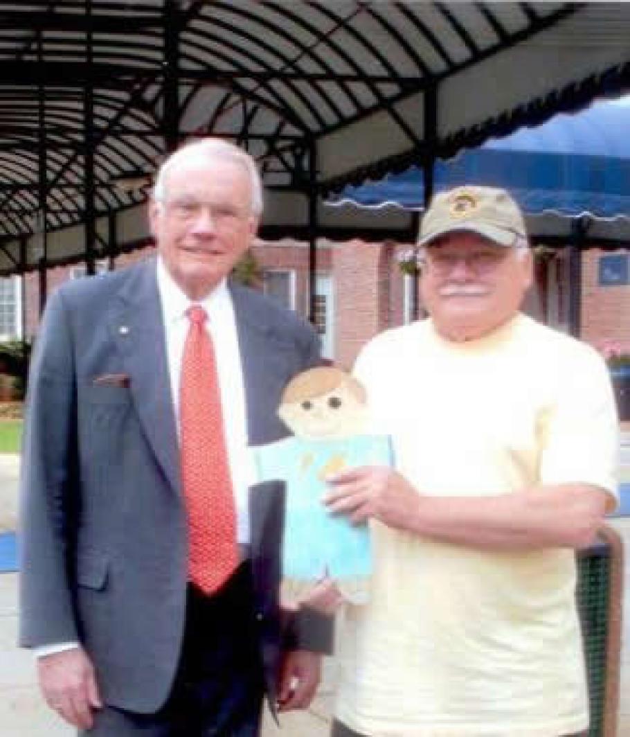 Neil Armstrong smiles for a photo with Tom Crouch, a curator, holding a Flat Stanley.